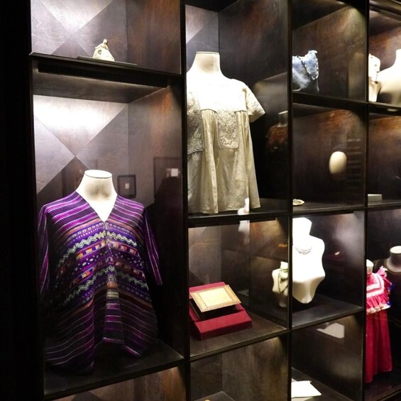 A display of traditional garments and pottery in a museum. 5