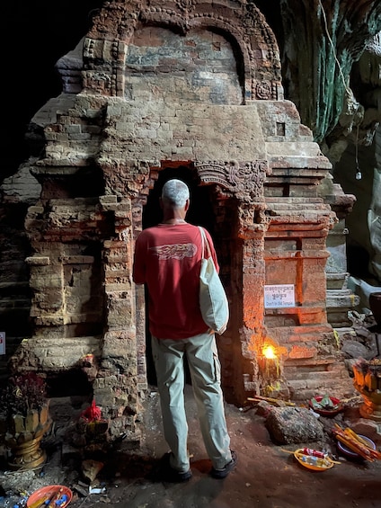 A man standing in front of an ancient temple with a sign reading "Don't In Old Temple". 1