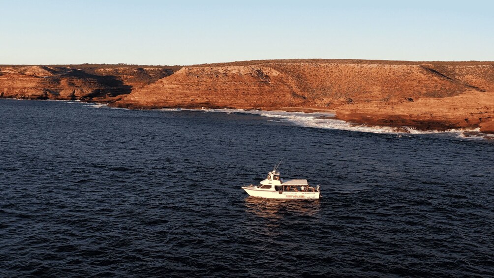 A boat on a river with a rocky landscape in the background. 3