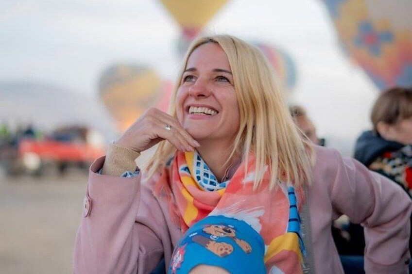 A person wearing a pink jacket and a colorful scarf with cartoon characters. 4