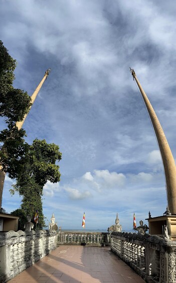 A temple with two large, curved structures and a statue in the background. 1