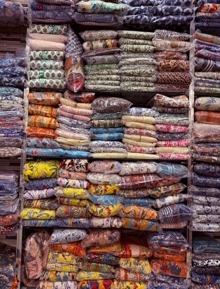 A variety of colorful fabrics stacked in bins. 3