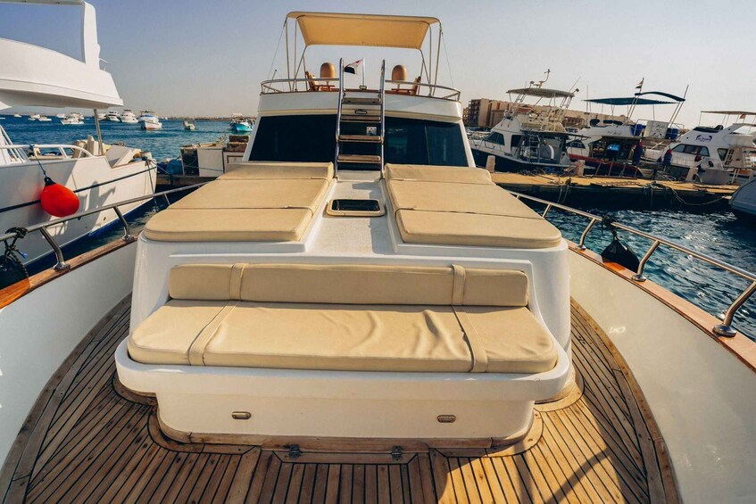 A boat deck with cushioned seating and a wooden floor. 3