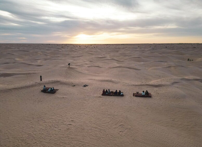 A desert landscape with dunes and a sunset. 3