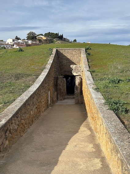 A stone structure with a pathway leading to an entrance. 3