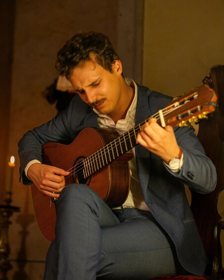 A person playing an acoustic guitar. 5