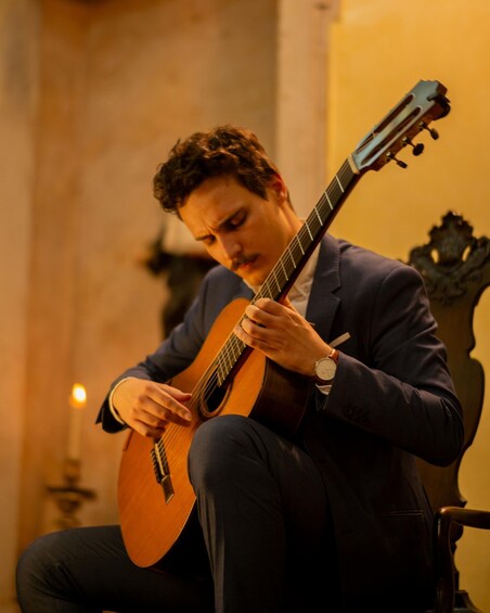 A person playing an acoustic guitar. 1