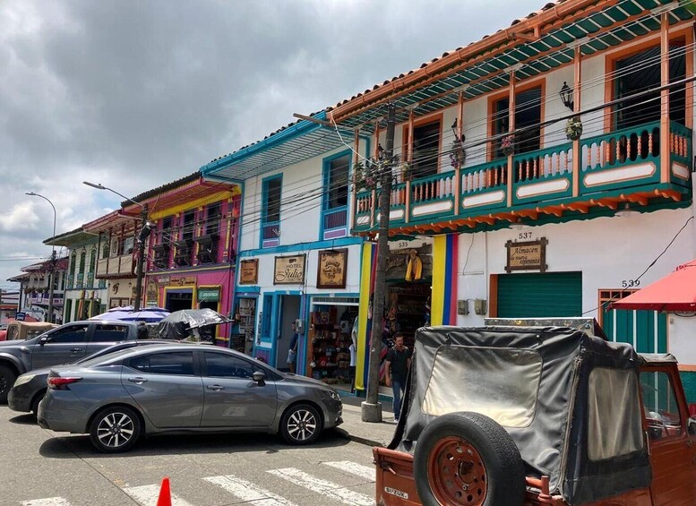 A street with colorful buildings, parked cars, and a covered vehicle. 5