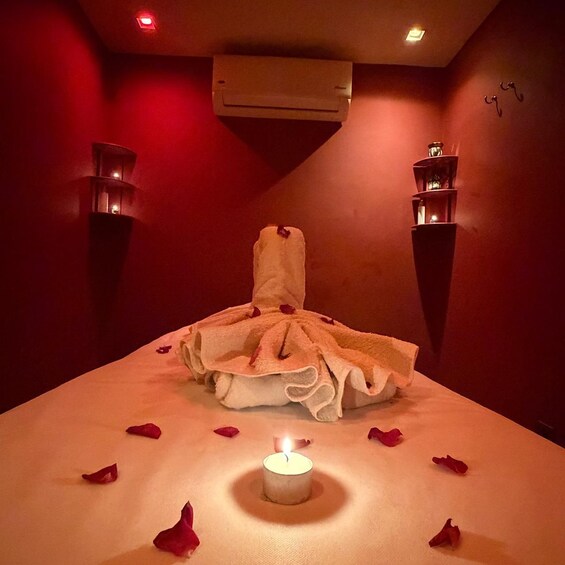 Et spa-værelse med massagestol, stearinlys og rosenblade. 2
