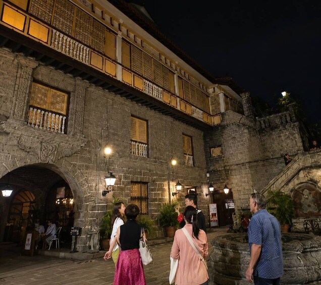 A historic stone building with ornate balconies and a courtyard at night. 5