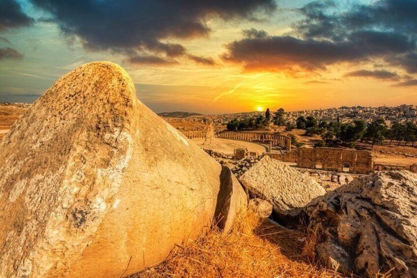 A large rock formation, a historic building, and a sunset over a cityscape. 2