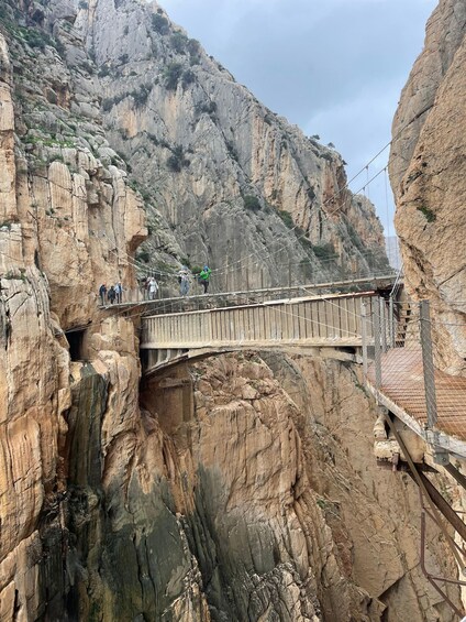 A suspension bridge over a canyon with rocky cliffs. 5