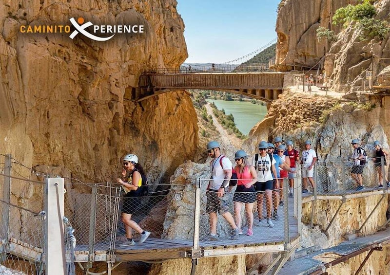A group of people on a suspension bridge over a canyon with a river below. 1
