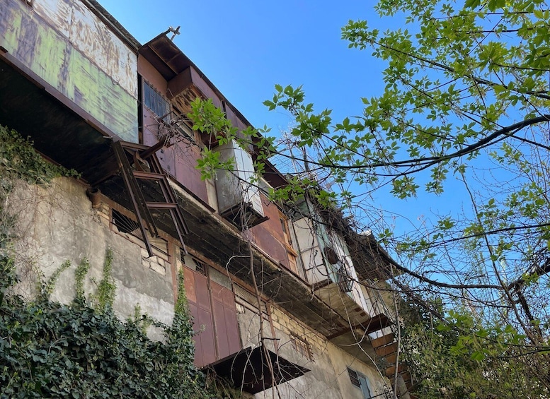 A dilapidated building with visible rust and overgrown vegetation. 3