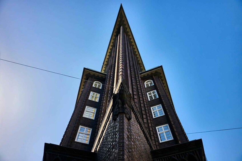 A tall, pointed building with a triangular roof and multiple windows. 1