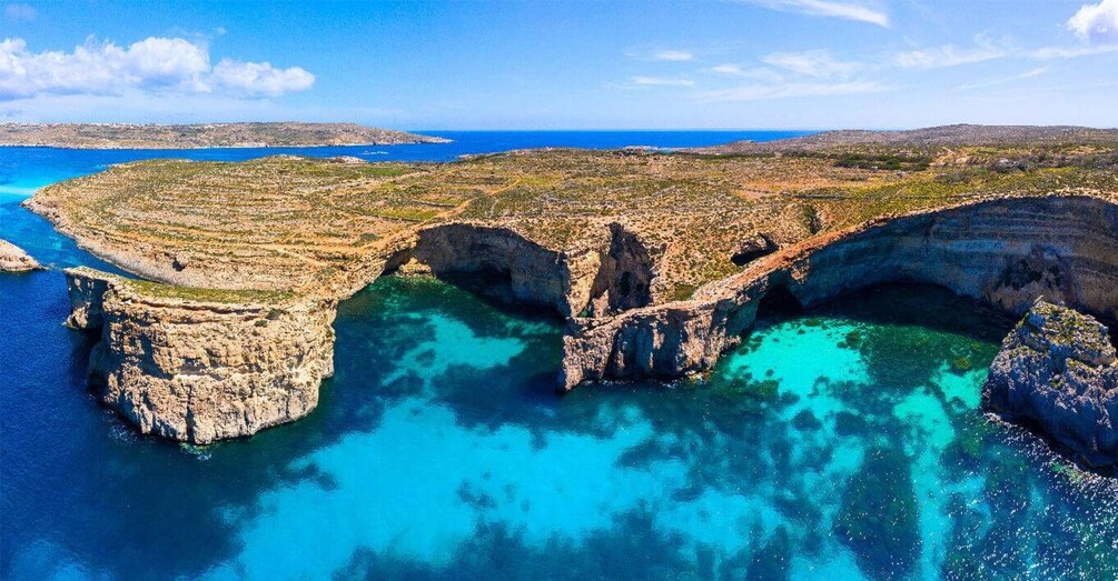A coastal landscape with rocky cliffs and clear turquoise waters. 2