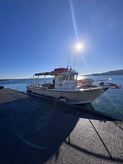 A boat docked at a pier with a clear sky and calm water. 3