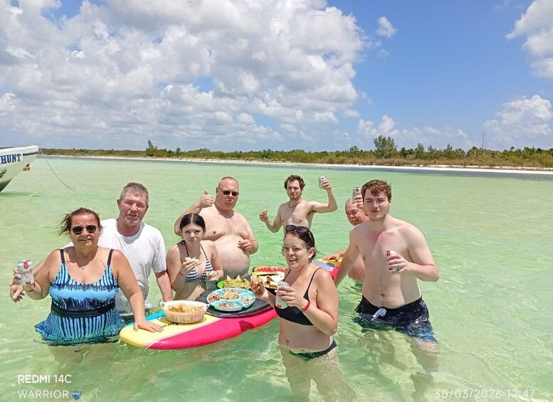 A group of people in shallow water with a boat labeled 'HUNT' in the background. 5