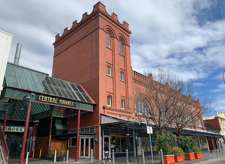 A red brick building with a sign reading 'CENTRAL MARKET' and a green awning. 5