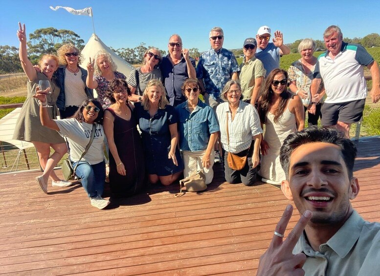 A group of people on a wooden deck with a tent in the background. 3
