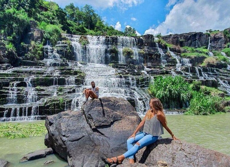 A waterfall cascading over rocky terrain with lush greenery. 1