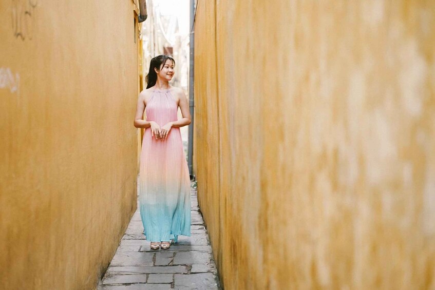 A person walking down a narrow alleyway with yellow walls. 3
