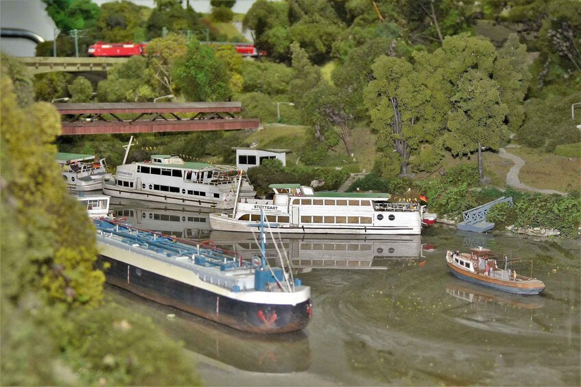 A model of a river with boats, a bridge, and trees. 5