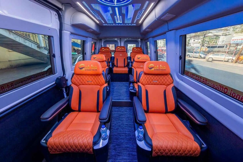 A train interior with orange seats and a blue carpet. 2