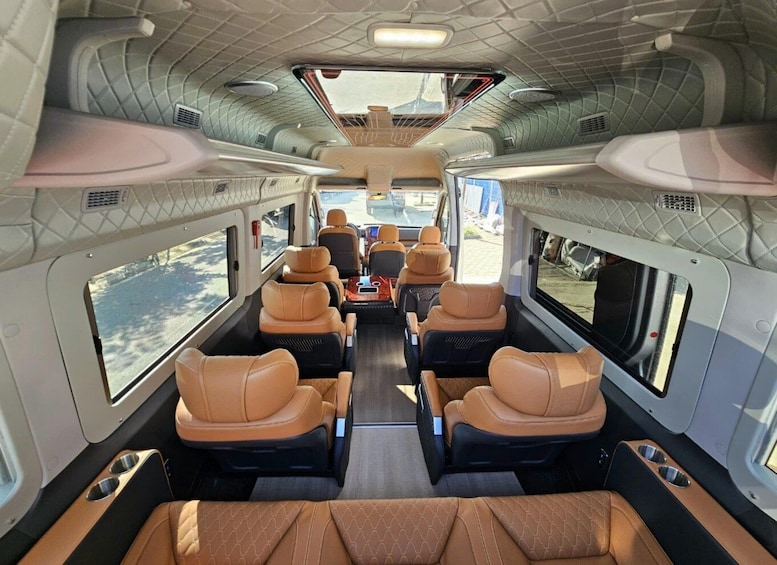 The interior of a train with leather seats and a central aisle. 4