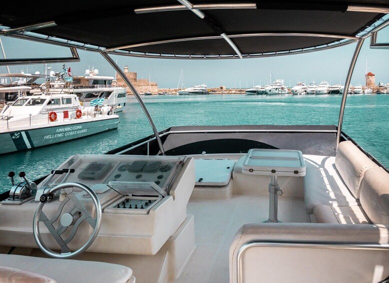 A boat's control station with a view of a marina filled with yachts. 3