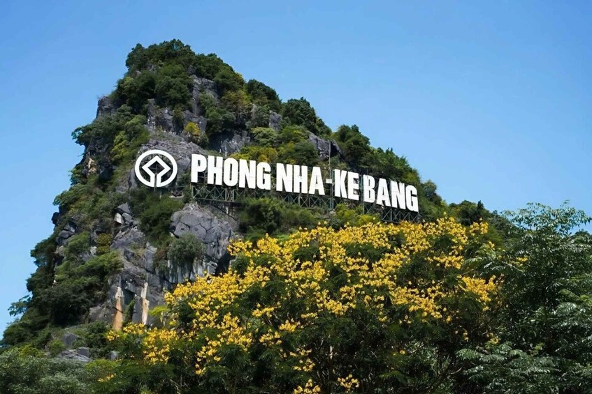A mountain with a sign reading 'PHONG NHA-KE BANG' and a logo. 2