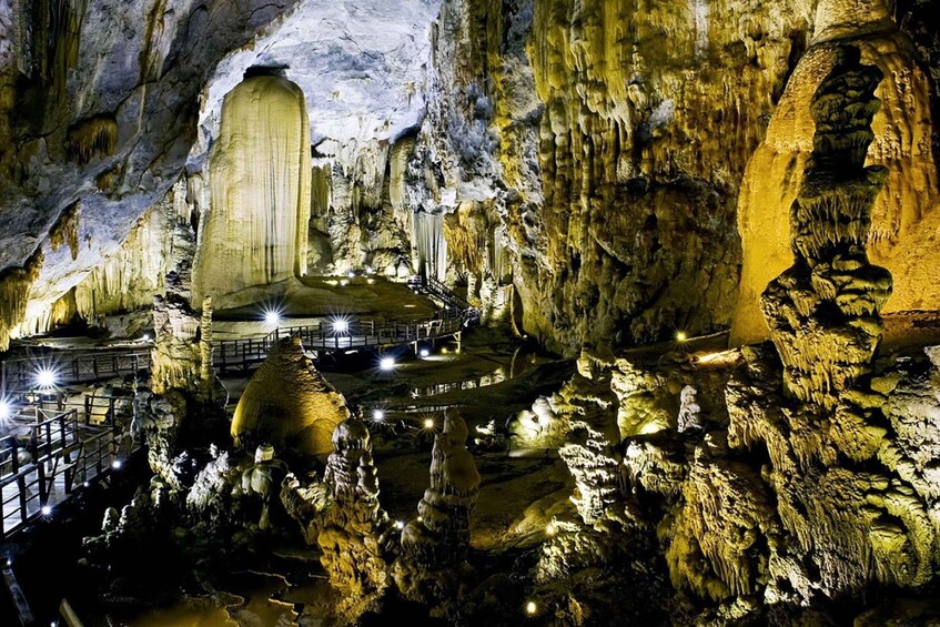 A cave with stalactites, a large stalagmite, and a viewing platform. 4