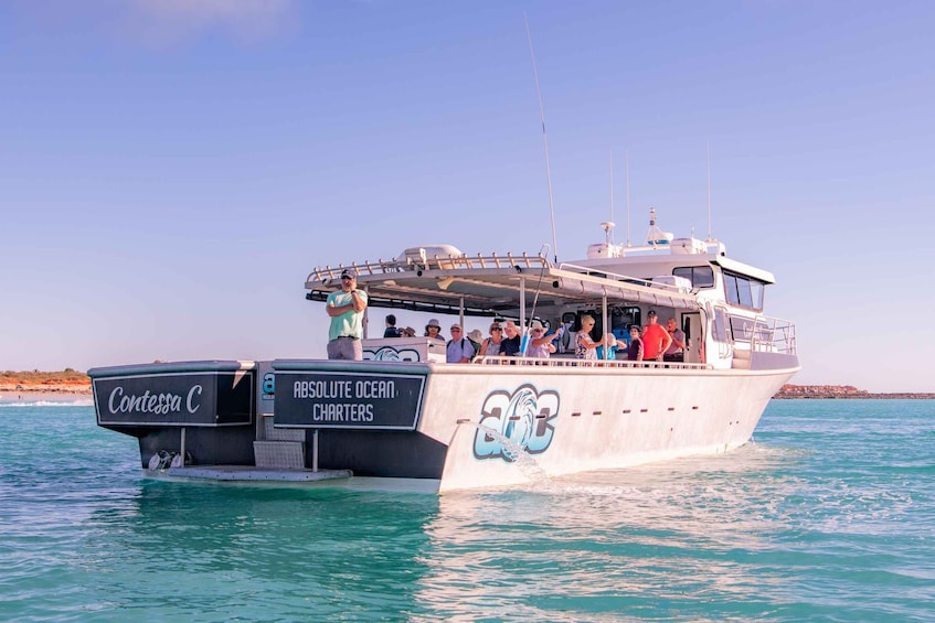 A boat named 'Contessa C' with 'ABSOLUTE OCEAN CHARTERS' written on its side, sailing on clear blue waters. 4