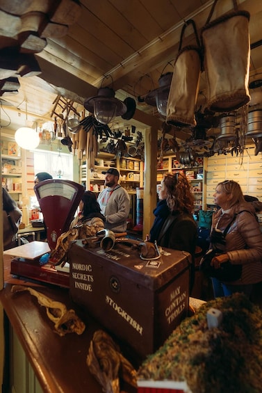 A bar with wooden shelves, hanging utensils, and a cash register. 3