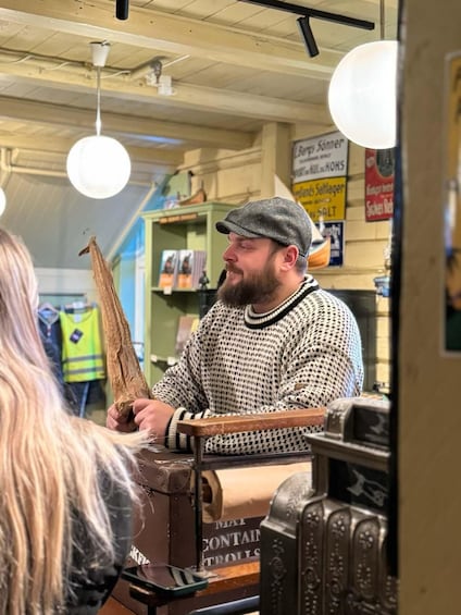 A person in a patterned sweater and cap at a market stall with a cardboard box. 5