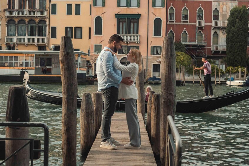 A couple embracing on a wooden pier in Venice, with gondolas and a gondolier in the background. 2