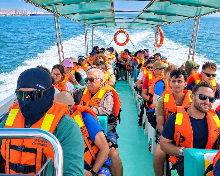 A boat with passengers wearing orange life jackets. 1