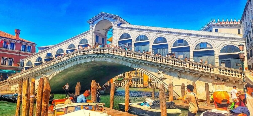A historic bridge with people walking and boats docked nearby. 5
