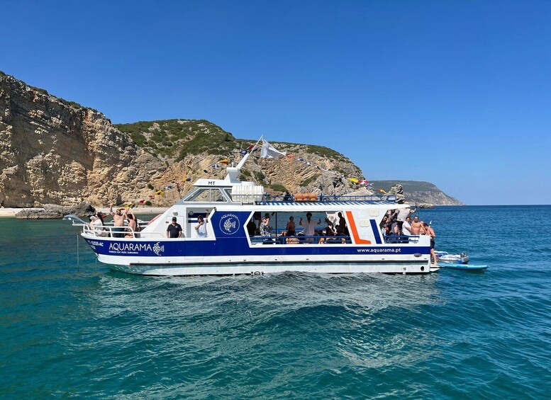 A boat named AQUARAMA on a calm sea with rocky cliffs in the background. 5