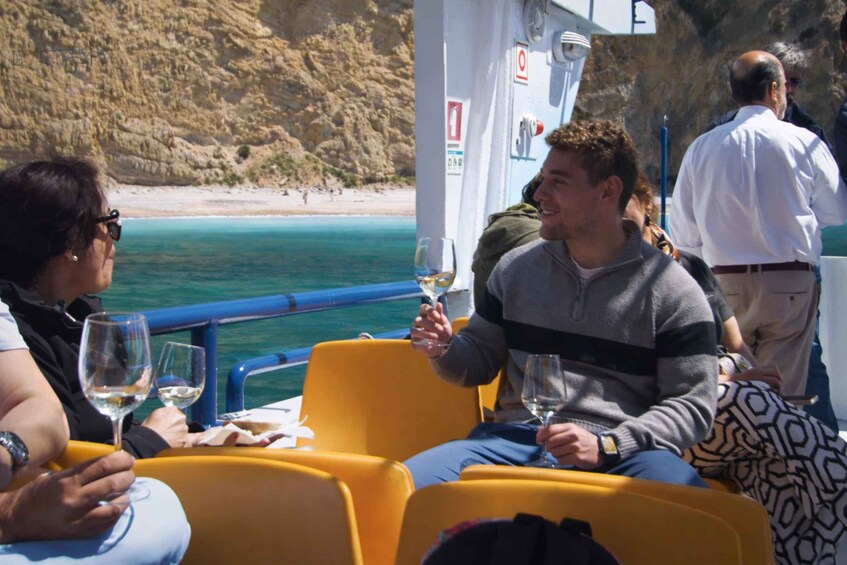 People on a boat with a rocky coastline in the background. 3