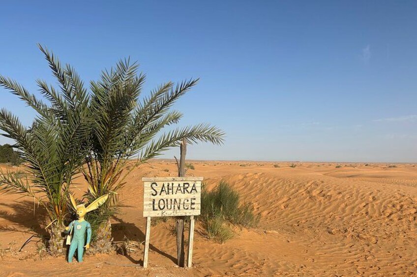 A desert landscape with a sign reading 'Sahara Lounge.' 5