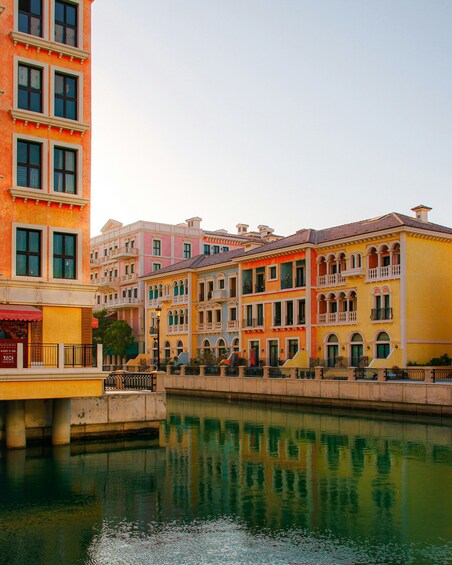 A canal with colorful buildings reflecting on the water. 4