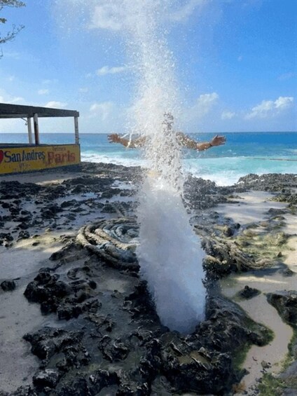 A splash of water, a rocky shoreline, and a sign that reads 'San Andres Paris'. 2