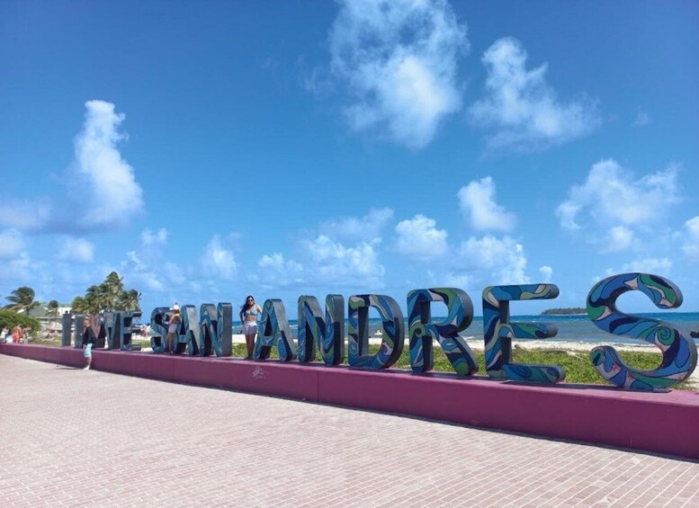 The word 'MEXICO' spelled out in colorful letters on a beachside promenade with a clear blue sky and ocean in the background. 3