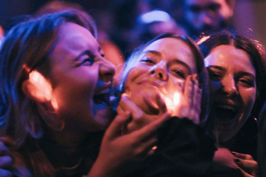 A group of people in a dimly lit environment, possibly a club or event venue. 3