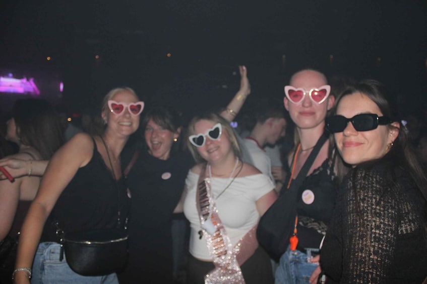 A group of people at a social event, some wearing heart-shaped sunglasses. 5