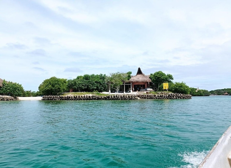 A tropical island with a thatched-roof hut and a small pier extending into turquoise waters. 3