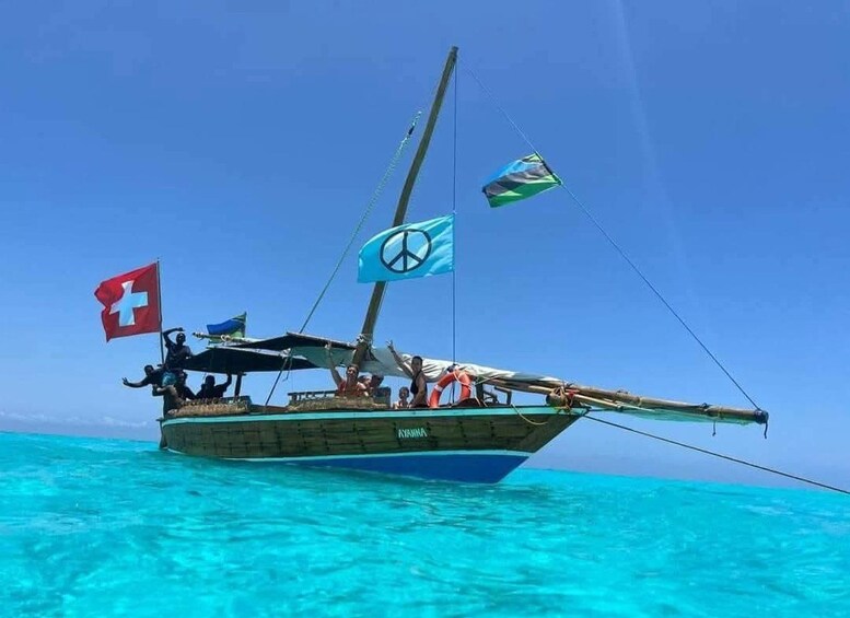 A boat with multiple flags, including a Swiss flag, a peace flag, and a flag with a blue background and a white cross. 1