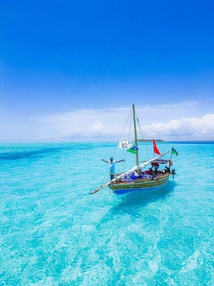 A traditional boat with multiple sails on turquoise water under a clear blue sky. 2