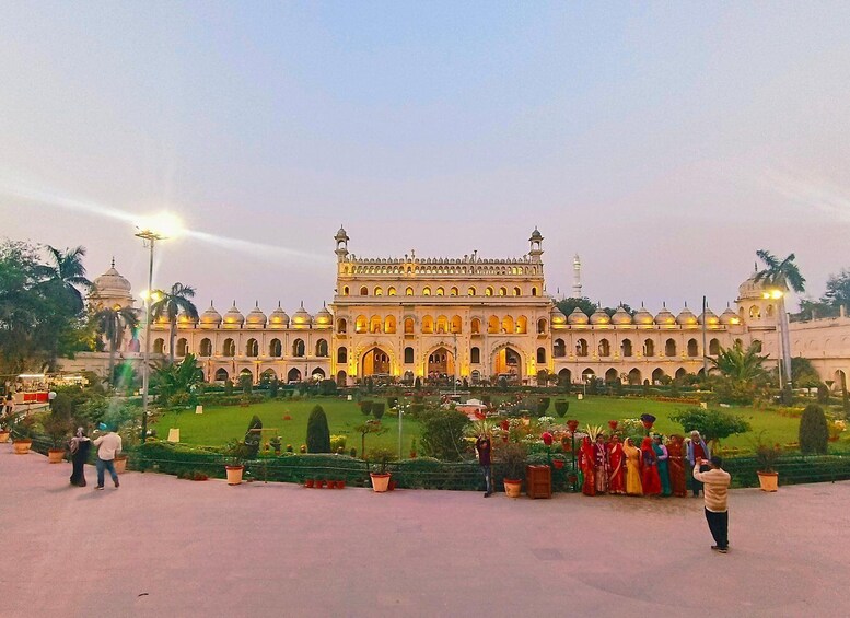A large, ornate building with domes and arches, surrounded by a well-maintained garden and palm trees. 4